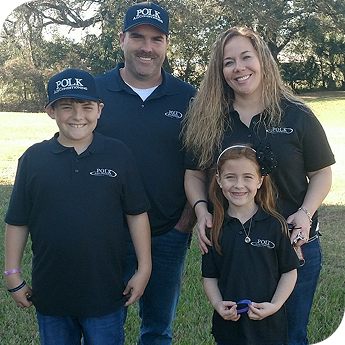 Owners of Polk Air Conditioning standing in a park with their two children