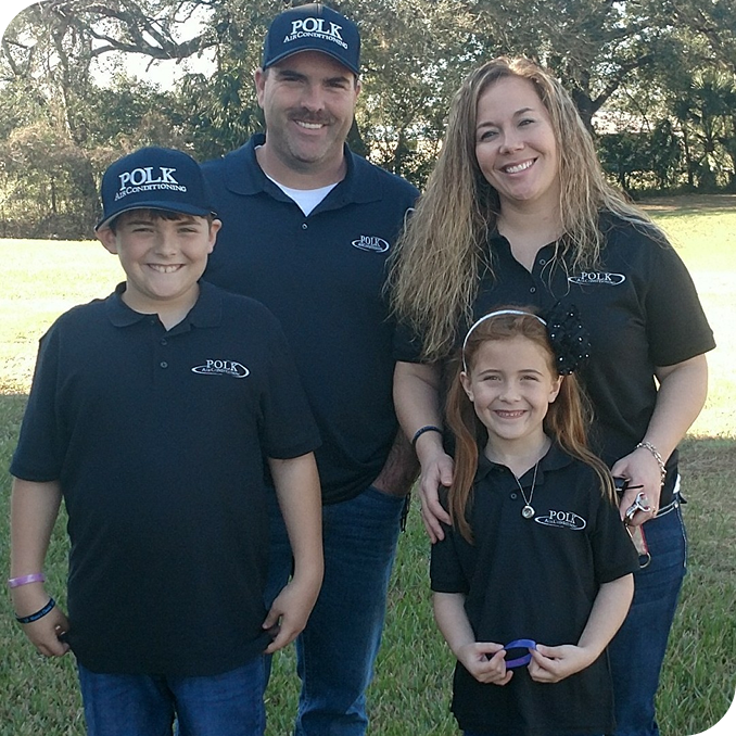 Owners of Polk Air Conditioning standing in a park with their two children