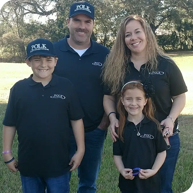 Owners of Polk Air Conditioning standing in a park with their two children